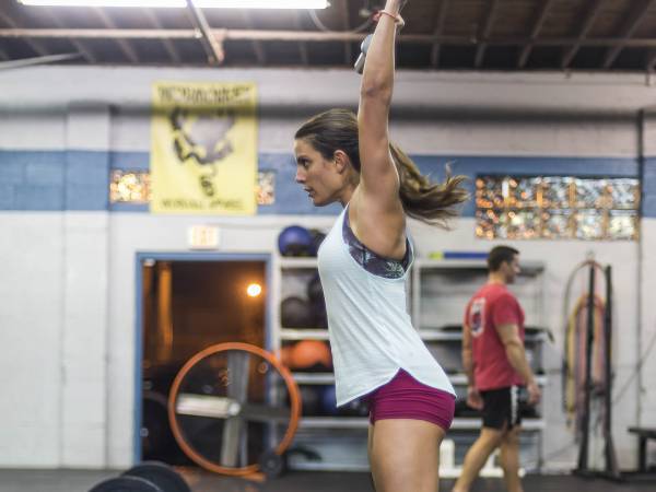 CrossFit empirical member pressing a barbell overhead