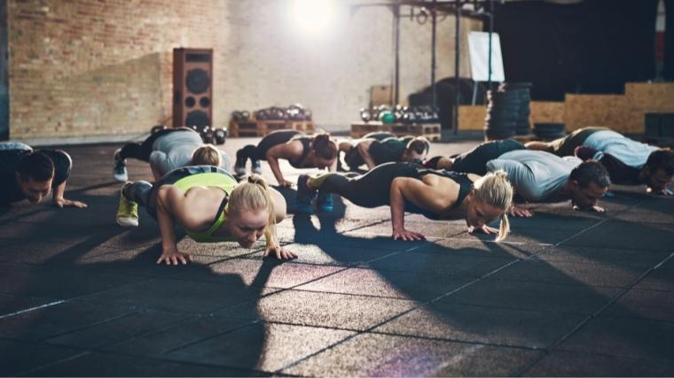 Un grupo de personas haciendo ejercicio juntas, realizando flexiones