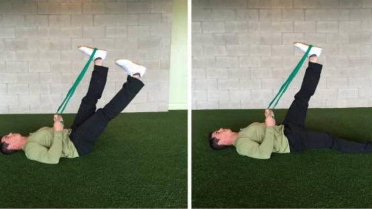 Man performing lower body mobility drills on floor with band