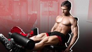 Muscular man performing seated leg extension exercise