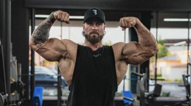 Chris Bumstead shows off his work with his arms in April 2022