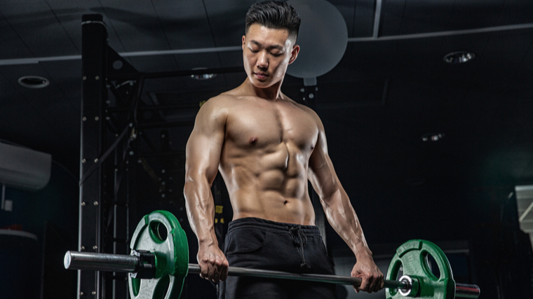 An Asian fitness model displays his biceps and pectoral muscles by