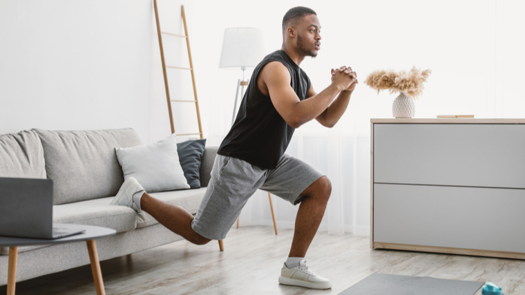 Man performing squat with one leg behind him on couch
