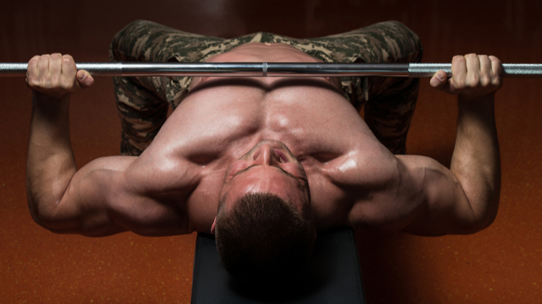Muscular bodybuilder performing bench press