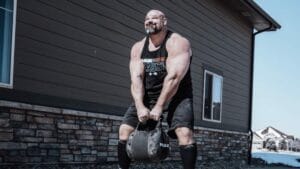 Brian Shaw carrying a sandbag kettle in May 2022