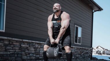 Brian Shaw carrying a sandbag kettle in May 2022
