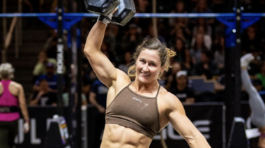 Tia-Clair Toomey smiling while holding a dumbbell in hand
