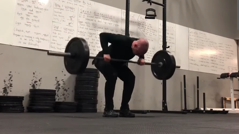 Man in gym performing barbell row