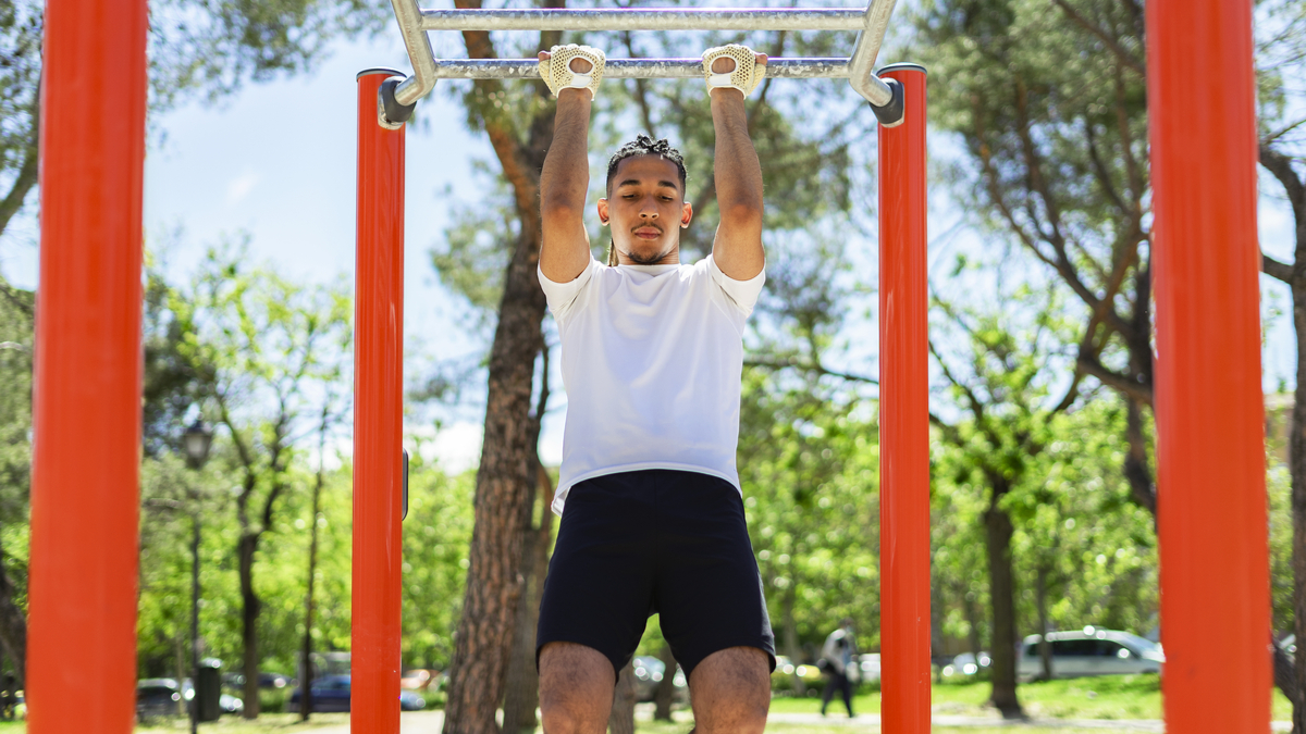 Man performing pull-ups outdoors
