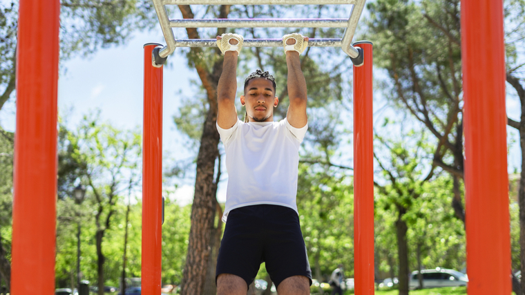 Man performing pull-ups outdoors