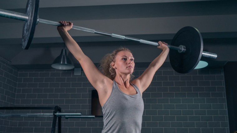 Woman performing overhead barbell exercise