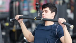 man in gym performing cable pulldown exercise