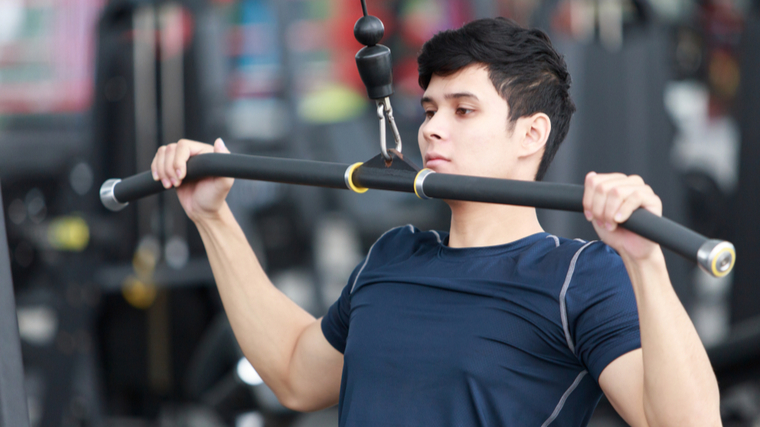 man in gym performing cable pulldown exercise