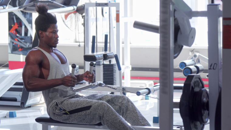 Man in gym performing seated cable row