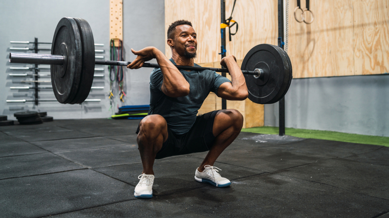 man in gym performing barbell front squat