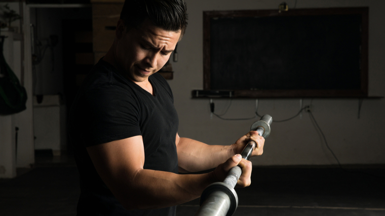 person in visionless gym curling barbell