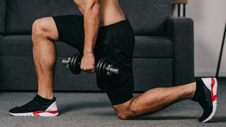 Person holding dumbbells in a lunge position