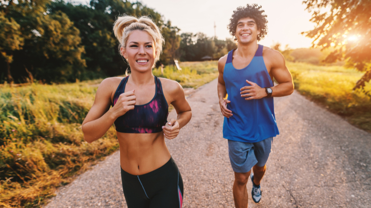 Two people running outdoors in the sunlight