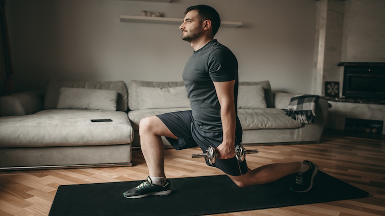 Person performing dumbbell lunges at home