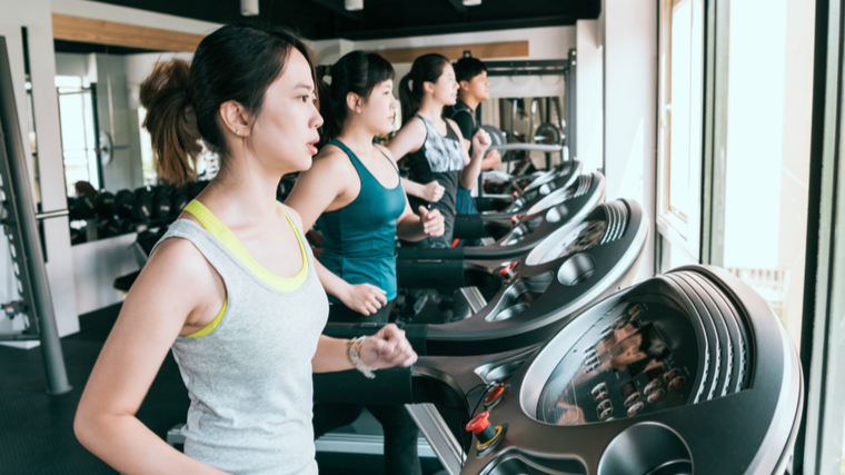 Several people running on treadmills in gym