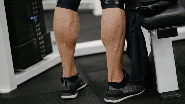 person with muscular calves standing in gym