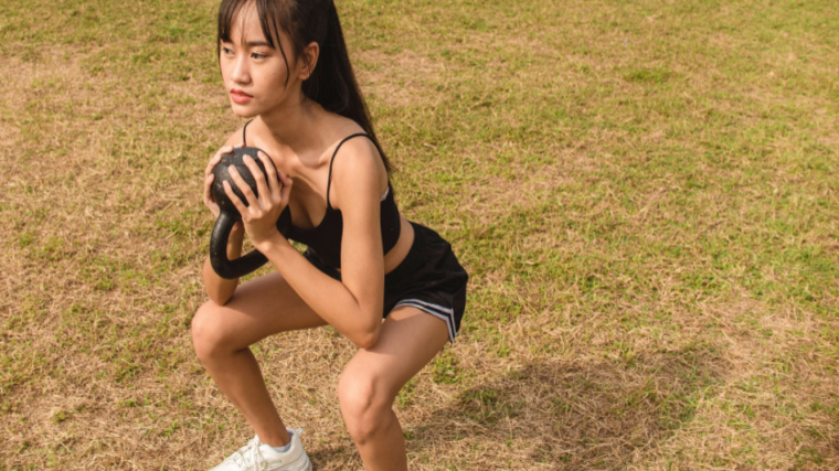 person outdoors performing kettlebell squat