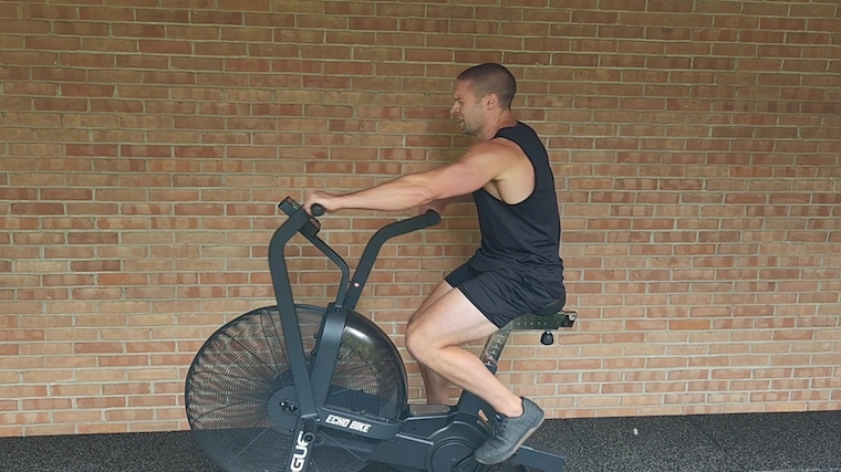 person straining on exercise bike