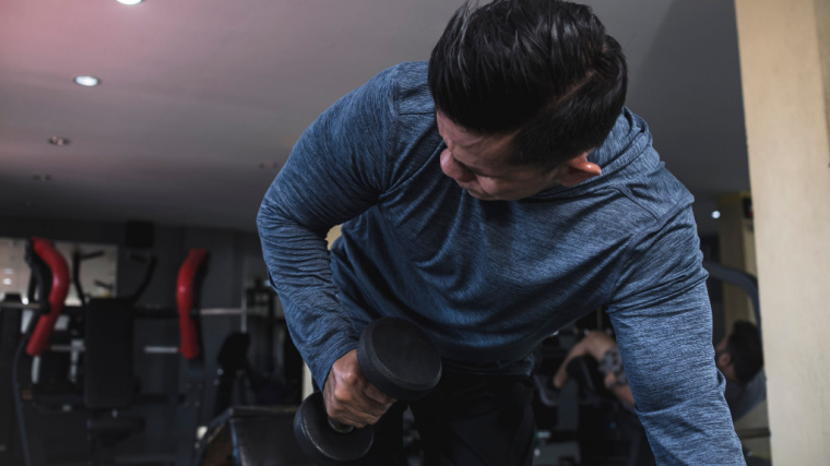 muscular person doing dumbbell triceps exercise