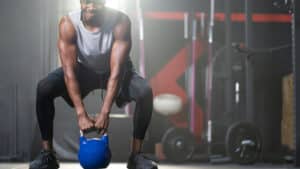 Person in gym lifting kettlebell