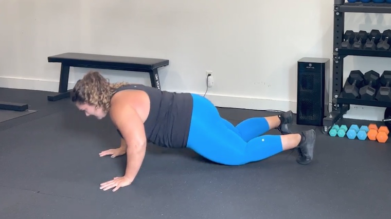 Person in gym doing push-up on knees