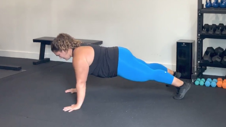 person in gym performing push-up plank