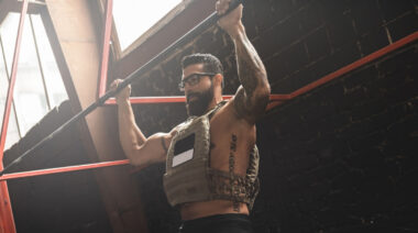 person wearing glasses performing weighted pull-up
