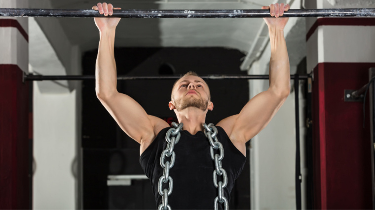 person doing pull-ups wearing chain