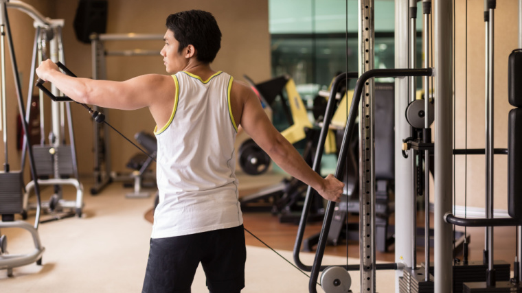 person in gym doing subscription shoulder exercise