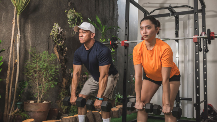 two people in gym doing dumbbell deadlift