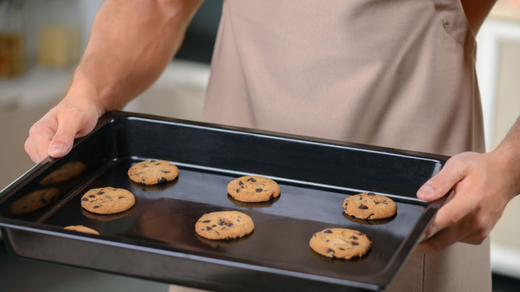 muscular person holding tray of cookies