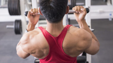 muscular person in gym doing back exercise