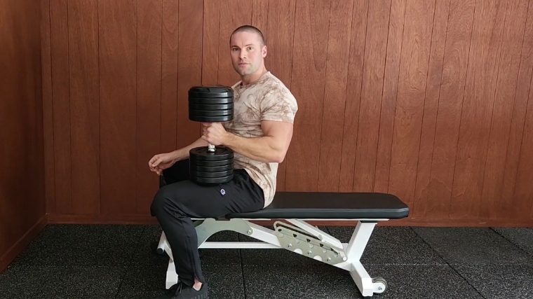 Step 5 - A person securely holding a dumbbell on his thigh at the end of a pullover set.
