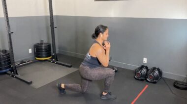 person in gym doing kettlebell lunge