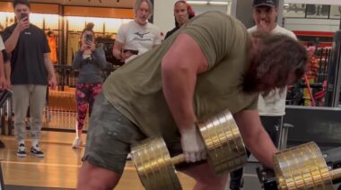 Strongman Martins Licis lifting golden dumbbell