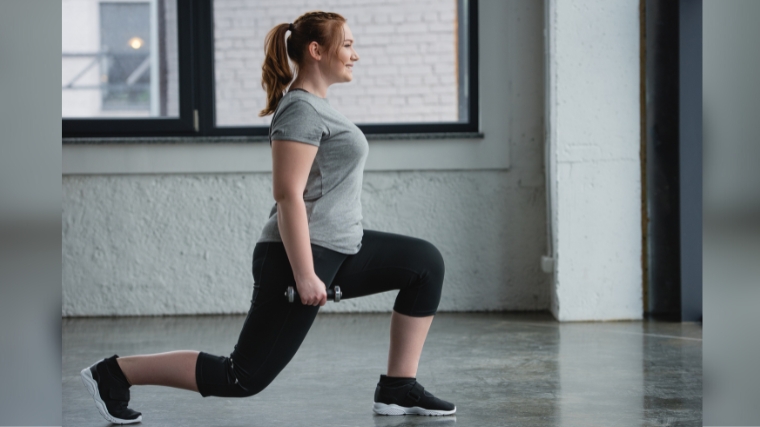 A person doing a dumbbell split squat with a straight back.