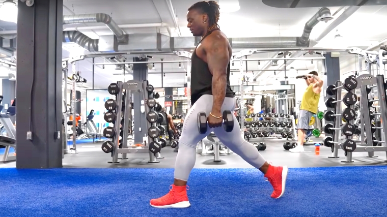 A person standing up during a dumbbell split squat.