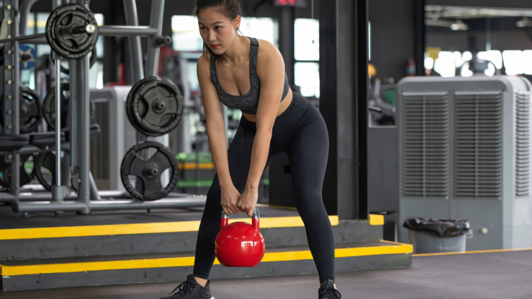 Person in gym lifting kettlebell