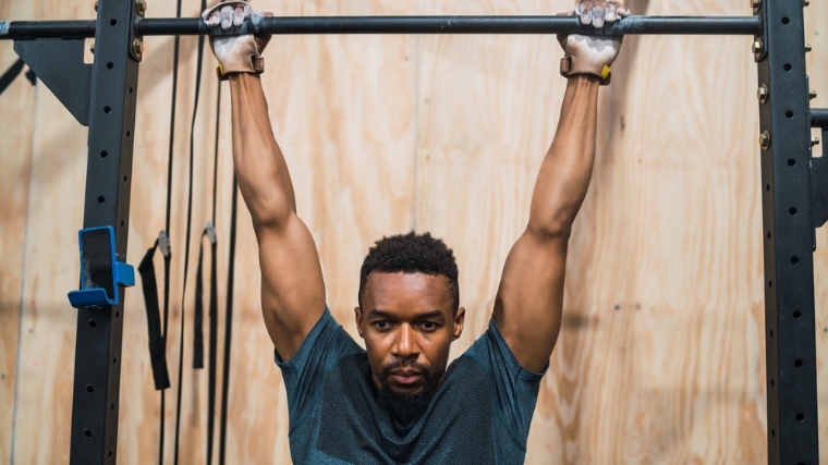 A person hanging from a pull-up bar.