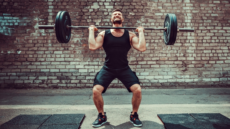 A person doing the third pull in a clean & jerk.