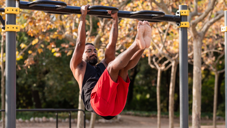 Person outdoors doing ab exercise on equipment