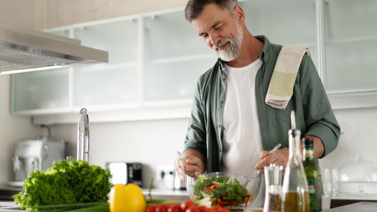 Gray-haired person cooking food in kitchen