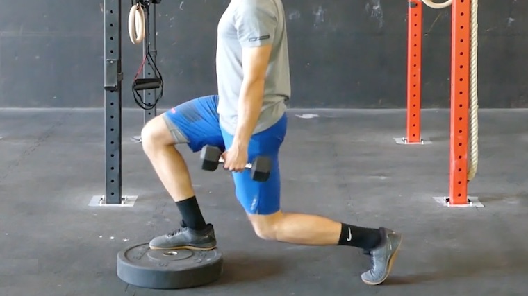 person in gym doing front foot elevated squat