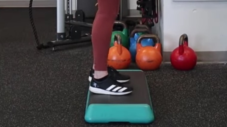 Person in gym standing on aerobic step