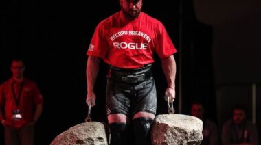 Strongman Kevin Faires carrying heavy stones